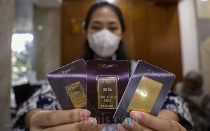 Karyawati memperlihatkan emas yang dijual di salah satu Galeri 24 Pegadaian di Jakarta, Senin (6/2/2023). Harga emas di Pegadaian pada perdagangan Senin (7/2) kompak stagnan untuk cetakan Antam dan cetakan UBS. Harga emas 24 karat Antam ukuran terkecil yakni 0,5 gram dijual seharga Rp580.000, kemudian emas 24 karat cetakan UBS dengan ukuran yang sama dijual pada harga Rp536.000. Bisnis/Arief Hermawan P