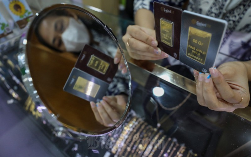 Karyawati memperlihatkan emas yang dijual di salah satu Galeri 24 Pegadaian di Jakarta, Senin (6/2/2023). Harga emas di Pegadaian pada perdagangan Senin (7/2) kompak stagnan untuk cetakan Antam dan cetakan UBS. Harga emas 24 karat Antam ukuran terkecil yakni 0,5 gram dijual seharga Rp580.000, kemudian emas 24 karat cetakan UBS dengan ukuran yang sama dijual pada harga Rp536.000. Bisnis/Arief Hermawan P