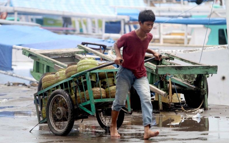 Pekerja memindahkan tabung 3 kilogram keatas kapal untuk didistribusikan di kepulauan sekitar Makassar, di Pelabuhan Paotere, Makassar, Sulawesi Selatan, Rabu (8/2/2023). PT Pertamina Patra Niaga menegaskan uji coba pembelian LPG 3 kilogram lewat pencocokan nomor induk kependudukan (NIK) KTP bakal tetap berlanjut pada tahun ini. Malahan, program itu bakal diperluas mencakup keseluruhan Pulau Jawa, Bali, dan Nusa Tenggara Barat pada implementasi tahap kedua. Bisnis/Paulus Tandi Bone