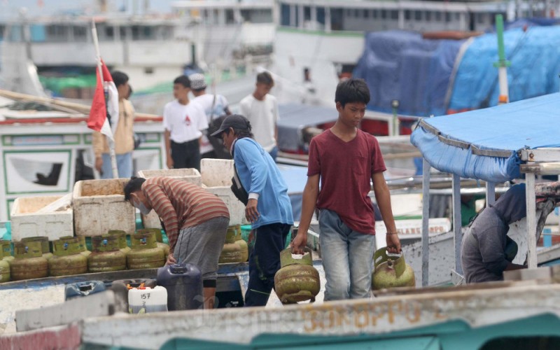 Pekerja memindahkan tabung 3 kilogram keatas kapal untuk didistribusikan di kepulauan sekitar Makassar, di Pelabuhan Paotere, Makassar, Sulawesi Selatan, Rabu (8/2/2023). PT Pertamina Patra Niaga menegaskan uji coba pembelian LPG 3 kilogram lewat pencocokan nomor induk kependudukan (NIK) KTP bakal tetap berlanjut pada tahun ini. Malahan, program itu bakal diperluas mencakup keseluruhan Pulau Jawa, Bali, dan Nusa Tenggara Barat pada implementasi tahap kedua. Bisnis/Paulus Tandi Bone