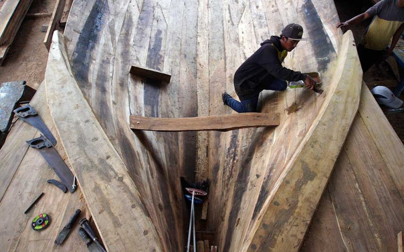 Pekerja menyelesaikan pembuatan kapal nelayan tradisional di Tambakrejo, Sumbermanjing Wetan, Malang, Jawa Timur, Rabu (15/3/2023). Pembuatan kapal nelayan berkapasitas 40 ton yang biasanya dikerjakan selama tiga bulan dengan biaya sekitar RP600 juta itu kini menghabiskan waktu enam bulan dengan biaya Rp800 juta per kapal yang disebabkan sulitnya mendapatkan bahan baku berupa kayu jati berkualitas. ANTARA FOTO/Irfan Sumanjaya