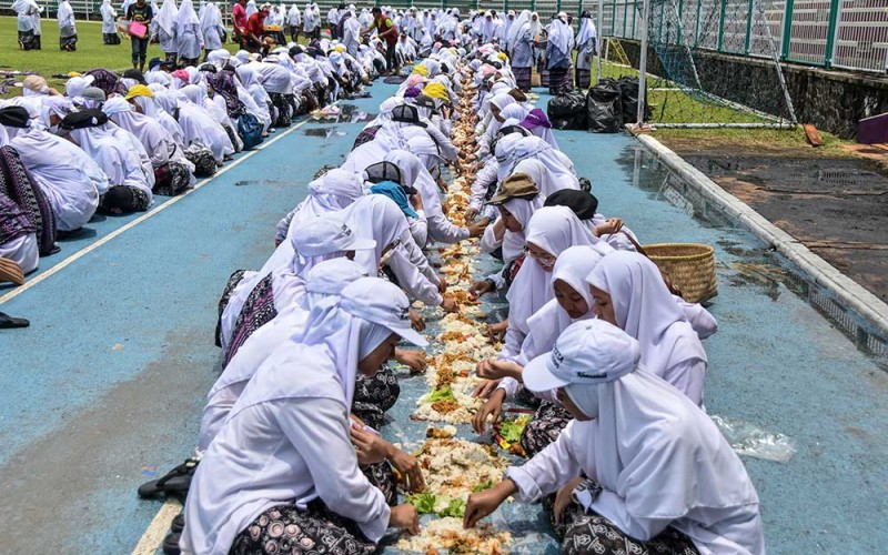 Sejumlah santri makan nasi liwet bersama saat mengikuti munggahan santri di Stadion Galuh, Kabupaten Ciamis, Jawa Barat, Senin (20/3/2023). Kegiatan tersebut bertujuan membangun kebersamaan dan persatuan pesantren se-Ciamis dengan menyediakan 1.001 kastrol berisi nasi liwet dalam rangka menyambut bulan suci RamadhanÂ 1444Â Hijriah. ANTARA FOTO/Adeng Bustomi