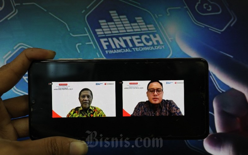 Layar menampilkan Ketua Indonesia Fintech Society Rudiantara (kiri) bersama dengan Managing Editor Bisnis Indonesia Galih Kurniawan (kanan) saat acara Dataindonesia.id Apresiasi Fintech 2023 di Jakarta, Selasa (21/3/2023). Industri fintech di Indonesia diproyeksikan terus tumbuh hingga 2027. Hal itu terlihat dari proyeksi nilai transaksi di lima segmen fintech dalam negeri seperti pembayaran digital, investasi digital, bank digital, pendanaan digital dan aset digital. Industri fintech ke depan diyakini mempunyai prospek sangat cerah. Di satu sisi, tantangan bagi penyelenggaraan fintech itu sendiri juga perlu mendapat perhatian. Bisnis/Eusebio Chrysnamurti