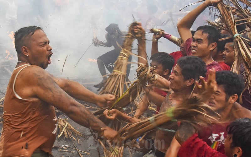 Sejumlah warga Hindu saling serang menggunakan api yang disulut pada bobok (seikat daun kelapa kering) saat mengikuti tradisi perang api di Lingkungan Negara Sakah, Mataram, NTB, Selasa (21/3/2023). Tradisi perang api yang merupakan rangkain acara menyambut Hari Raya Nyepi tersebut melibatkan ratusan warga Hindu yang saling serang dengan api yang menggambarkan pembakaran hawa nafsu buruk yang ada dalam diri manusia agar benar-benar suci sebelum memulai acara Nyepi. ANTARA FOTO/Ahmad Subaidi