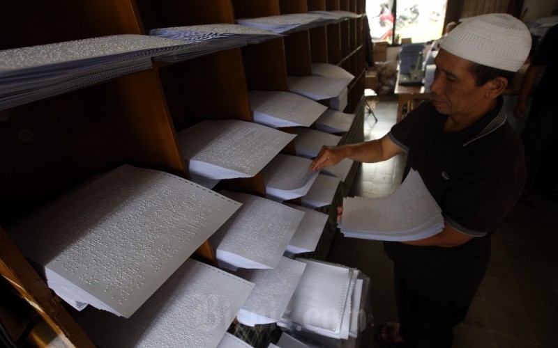 Pekerja menyelesaikan pembuatan Alquran braille menggunakan mesin braille press di Percetakan Braille Yayasan Penyantun Wyata Guna (YPWG), Bandung, Jawa Barat, Senin (27/3/2023). Meski masih menggunakan mesin konvensional, percetakan Braille YPWG, saat ini mampu membuat 100 set Alquran braille per bulan dengan target 600 set hingga bulan Juni 2023 nanti. Pengurus YPWG mengungkapkan bahwa saat ini yang bisa baca tulis Alquran braille di Indonesia kurang dari 10 persen dari jumlah total muslim tunanetra di Indonesia. Untuk itu, pemberantasan buta huruf Alquran braille harus dipercepat. Bisnis/Rachman