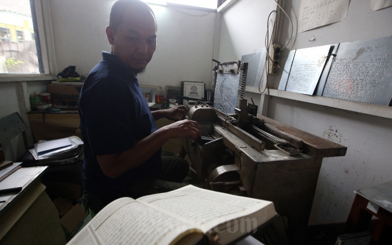 Pekerja menyelesaikan pembuatan Alquran braille menggunakan mesin braille press di Percetakan Braille Yayasan Penyantun Wyata Guna (YPWG), Bandung, Jawa Barat, Senin (27/3/2023). Meski masih menggunakan mesin konvensional, percetakan Braille YPWG, saat ini mampu membuat 100 set Alquran braille per bulan dengan target 600 set hingga bulan Juni 2023 nanti. Pengurus YPWG mengungkapkan bahwa saat ini yang bisa baca tulis Alquran braille di Indonesia kurang dari 10 persen dari jumlah total muslim tunanetra di Indonesia. Untuk itu, pemberantasan buta huruf Alquran braille harus dipercepat. Bisnis/Rachman