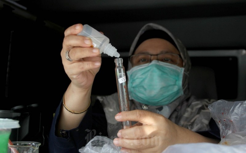 Petugas Badan Pengawas Obat dan Makanan (BPOM) Makassar menguji sampel makanan berbuka puasa atau takjil yang dijual pedagang kaki lima di mobil laboratorium di Makassar, Sulawesi Selatan, Senin (27/3/2023). Dari sejumlah makanan yang diambil sampelnya kemudian diuji di mobil laboratorium dan menunjukkan hasil yang negative serta layak dikonsumsi. Bisnis/Paulus Tandi Bone