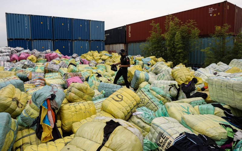 Petugas memeriksa pakaian bekas yang disita di Bekasi, Jawa Barat, Selasa (28/3/2023). Bea Cukai bekerja sama dengan Badan Reserse Kriminal Kepolisian Republik Indonesia (Bareskrim Polri) menyita 7.363 bal pakaian bekas (balepress) asal impor senilai lebih dari 80 miliar rupiah di wilayah Jabodetabek. Penindakan ini merupakan tindak lanjut arahan Presiden Republik Indonesia terkait penanganan peredaran pakaian bekas ilegal impor yang mengganggu industri tekstil dalam negeri. Bisnis/Abdurachman