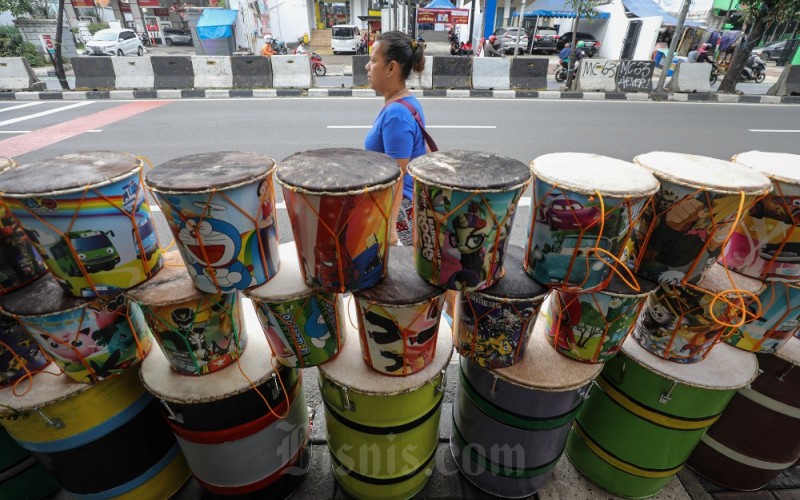 Warga melintas di antara bedug yang dijual di kawasan Tanah Abang, Jakarta, Selasa (28/3). Beragam bedug tersebut ditawarkan dengan harga Rp100 ribu - Rp400 ribu tergantung ukuran. Menurut pedagang, penjualan bedug pada awal Ramadan tahun ini mengalami peningkatan signifikan dibandingkan dengan tahun lalu. Bisnis/Arief Hermawan P