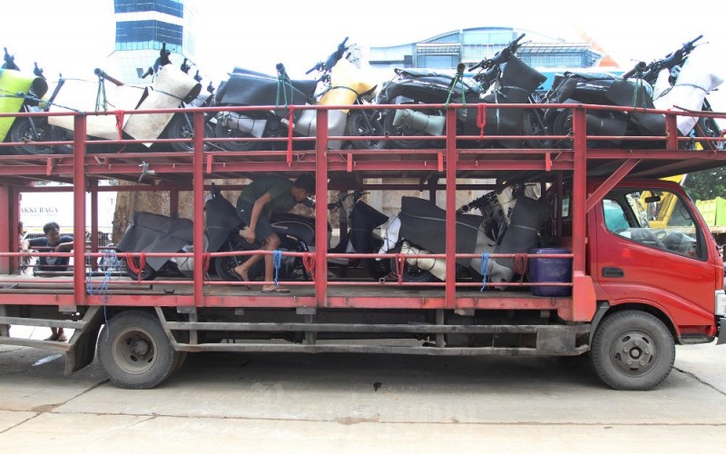 Pekerja memindahkan sepeda motor yang baru diturunkan dari kapal untuk dikirim ke dealer di Pelabuhan Makassar, Sulawesi Selatan, Selasa (28/3/2023). Berdasarkan data Asosiasi Industri Sepeda Motor Indonesia (AISI) penjualan kendaraan bermotor roda dua pada Januari 2023 tercatat mencapai 608.244 unit atau tumbuh 37 persen secara tahunan (year-on-year/yoy). Bisnis/Paulus Tandi Bone