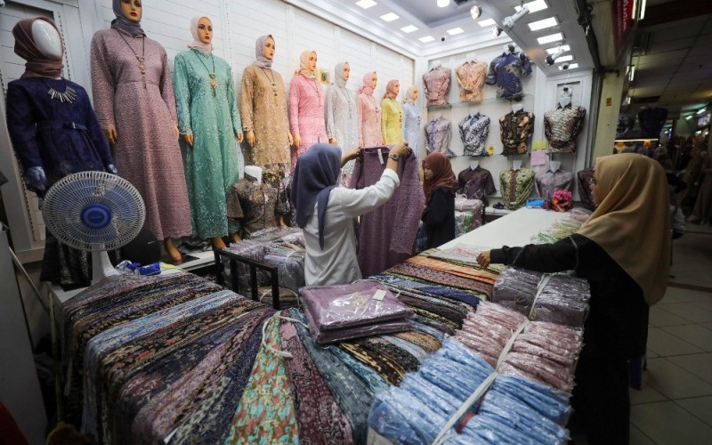 Pedagang melayani pembeli pakaian dan perlengkapan muslim di Pasar Tanah Abang, Jakarta, Rabu (29/3/2023). Memasuki pekan pertama bulan Ramadan, penjualan busana muslim masih terlihat normal. Para pedagang memprediksi, penjualan pakaian muslim baru akan diserbu oleh pengunjung pada sekitar dua minggu jelang Hari Raya Idul Fitri. Bisnis/Himawan L Nugraha