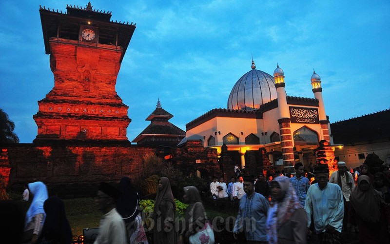 Sejumlah umat Islam berjalan di depan Masjid Menara Kudus atau bernama resmi Masjid Al Aqsa Manarat Qudus di Desa Kauman, Kudus, Jawa Tengah, Jumat (31/3/2023). Masjid bersejarah yang dibangun pada masa Sunan Kudus atau Syekh Ja'far Shodiq pada tahun 956 H atau1549 M itu memiliki arsitektur perpaduan budaya Islam dengan budaya Hindu-Jawa dan ramai untuk kegiatan keagamaan selama bulan Ramadhan. ANTARA FOTO/Yusuf Nugroho
