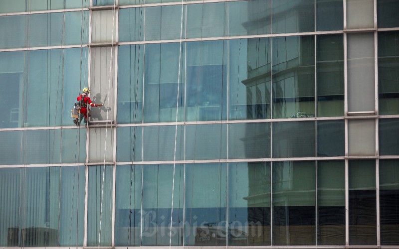 Pekerja membersihkan kaca gedung di Jakarta, Sabtu (1/4/2023). Badan Penyelenggara Jaminan Sosial Ketenagakerjaan (BPJSTK) menargetkan 46 juta peserta pada 2023. Target tersebut 10 juta lebih tinggi dibandingkan tahun lalu yakni kurang lebih 36 juta peserta. Bisnis/Abdurachman