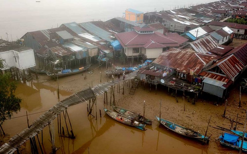 Foto udara saat dua warga berdiri di ujung jembatan yang rusak di Tanjung Solok, Tanjung Jabung Timur, Jambi, Rabu (24/5/2023). Jembatan yang dibangun dengan konstruksi panggung kayu sepanjang sekitar 300 meter di atas kawasan hutan bakau sejak belasan tahun lalu untuk menghubungkan beberapa RT di pesisir Kuala Jambi itu rusak dan tidak bisa dilewati sejak Selasa (23/5/2023) sehingga menghambat mobilitas warga. ANTARA FOTO/Wahdi Septiawan
