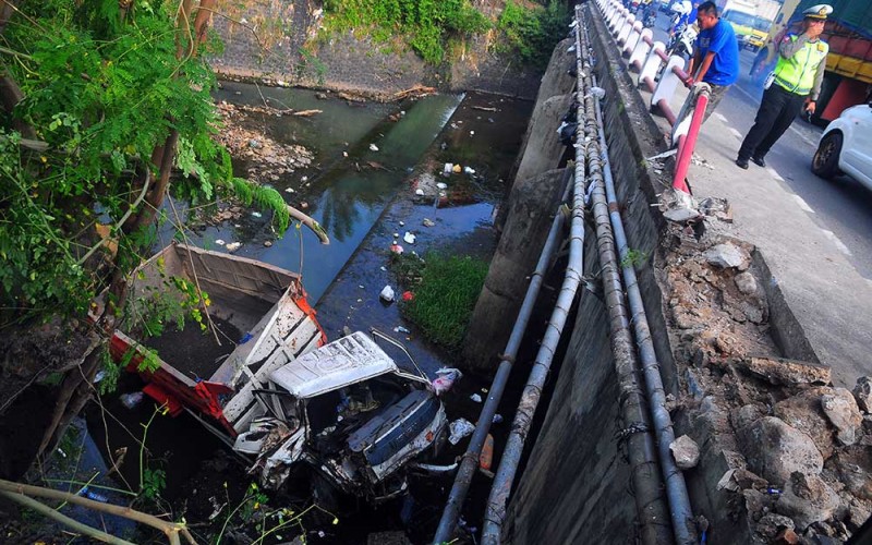 Warga melihat sebuah truk yang mengalami kecelakaan dan jatuh ke Sungai Logung di jalur pantura, Jekulo, Kudus, Jawa Tengah, Selasa (30/5/2023). Kecelakaan tunggal tersebut akibat pengemudi truk mengantuk sehingga menabrak pembatas jembatan dan jatuh ke sungai serta menyebabkan satu orang luka-luka. ANTARA FOTO/Yusuf Nugroho