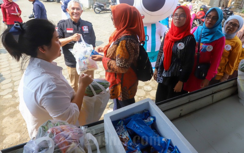 Brand Manager Aice Group Sylvana Zhong (kiri) dan Founder Foodbank of Indonesia (FOI) M. Hendro Utomo (kedua kiri) membagikan sembako kepada sejumlah guru PAUD Melur Bangsa 011 Petamburan dalam acara 15 Hari Aice Berbagi Sehat di Jakarta, Rabu (31/5/2023). Bisnis/Suselo Jati