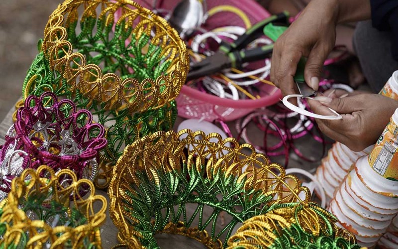 Perajin menyelesaikan proses pengguntingan sampah gelas plastik di Balai Desa Sani-Sani, Kolaka, Sulawesi Tenggara, Senin (5/6/2023). Perajin yang sebagian ibu-ibu rumah tangga memanfaatkan limbah sampah plastik gelas diubah menjadi barang bernilai ekonomi seperti tempat gelas, tissu dan tempat sendok dan dijual dari Rp1,5 juta per set hingga Rp 2,5 juta per set tergantung ukuran dan tingkat kesulitan. ANTARA FOTO/Jojon