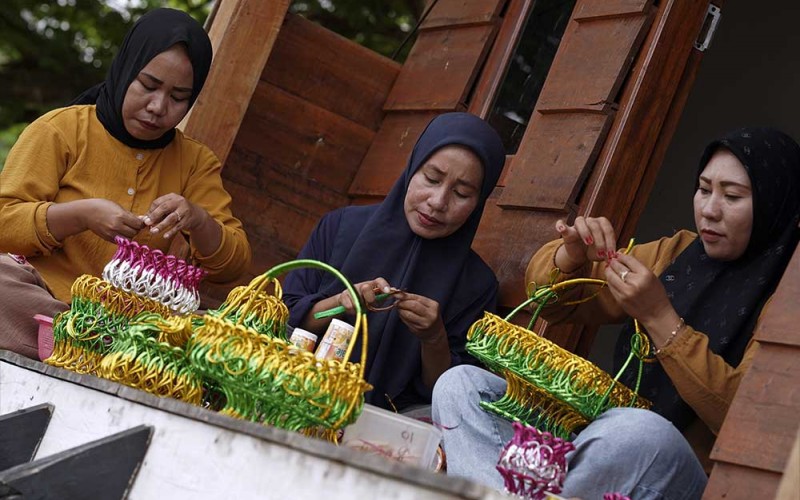 Perajin menyelesaikan proses pengguntingan sampah gelas plastik di Balai Desa Sani-Sani, Kolaka, Sulawesi Tenggara, Senin (5/6/2023). Perajin yang sebagian ibu-ibu rumah tangga memanfaatkan limbah sampah plastik gelas diubah menjadi barang bernilai ekonomi seperti tempat gelas, tissu dan tempat sendok dan dijual dari Rp1,5 juta per set hingga Rp 2,5 juta per set tergantung ukuran dan tingkat kesulitan. ANTARA FOTO/Jojon