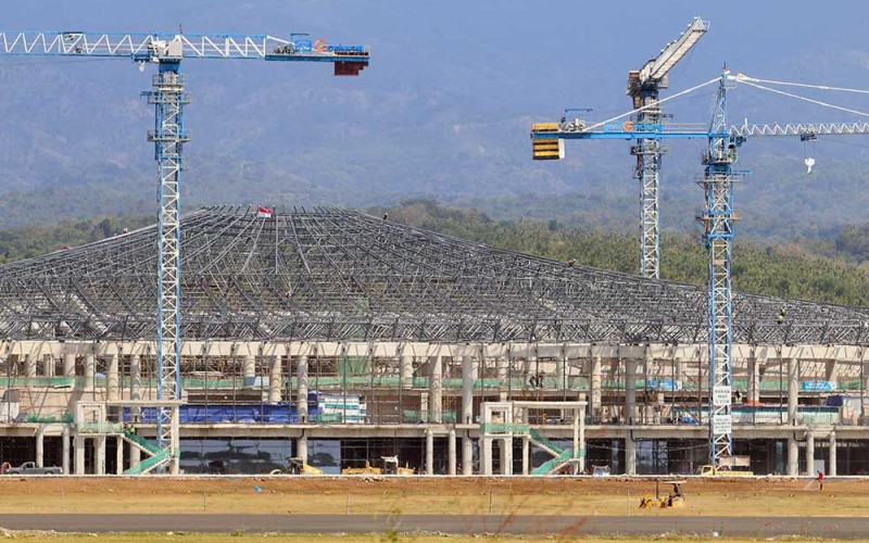 Pekerja beraktivitas pada proyek pembangunan Bandara Dhoho di Kediri, Jawa Timur, Selasa (6/6/2023). Proyek strategis nasional bandara pertama di Indonesia yang dibangun dengan pembiayaan swasta yang ditargetkan selesai pada akhir tahun 2023 tersebut akan dioperasikan oleh PT Angkasa Pura I sedangkan badan usaha pelaksana sekaligus pemilik aset PT Surya Dhoho Investama akan berperan sebagai pengelola bandara. ANTARA FOTO/Prasetia Fauzani