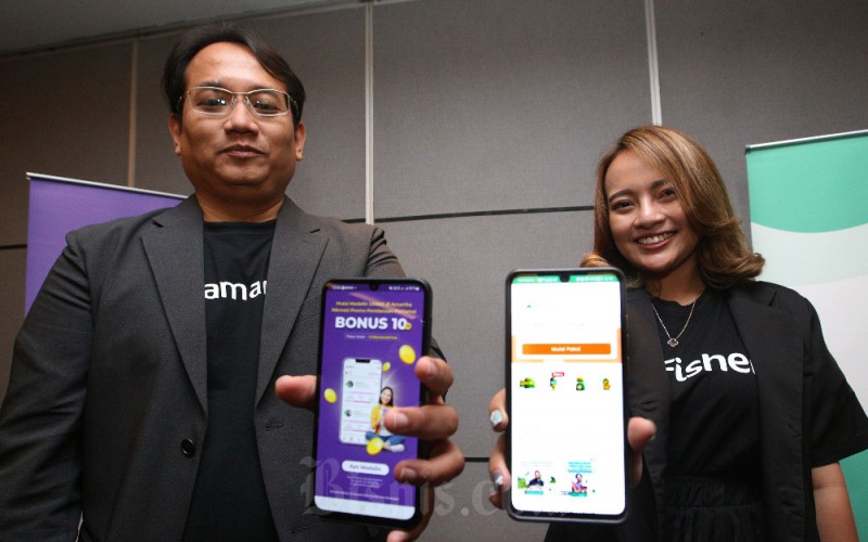 Business Head of Partnership Lending PT Amartha Mikro Fintek (Amartha) Adityo Putranto (kiri) dan Head of Fund & Operation PT Multidaya Teknologi Nusantara (eFishery) Diajeng Reisa Manik menunjukkan platform Amartha dan eFishery usai acara jumpa media di Bandung, Jawa Barat, Rabu (7/6/2023). Bisnis/Rachman