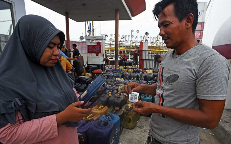 Petugas SPBU (kiri) menjelaskan cara menggunakan aplikasi pembelian solar pada telepon seluler kepada nelayan di Pelabuhan Perikanan Karangantu Kota Serang, Banten, Kamis (8/6/2023). PT Pertamina menekankan pentingnya penggunaan aplikasi dalam penyaluran BBM bersubsidi untuk nelayan agar tepat sasaran dan mencegah penyimpangan. ANTARA FOTO/Asep Fathulrahman