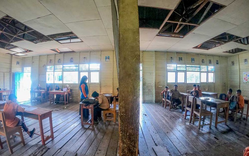 Seorang guru SDN 147 Senyerang mengajar siswa di ruang kelas yang rusak di Margo Rukun, Tanjung Jabung Barat, Jambi, Sabtu (10/6/2023). Sebanyak empat dari enam bangunan kelas milik sekolah yang berjarak sekitar 60 kilometer dari pusat Pemerintahan Kabupaten Tanjung Jabung Barat itu rusak parah pada bagian lantai dan atap sejak dua tahun terakhir, serta tidak memiliki bangunan toilet dengan jumlah murid mencapai 90 orang. ANTARA FOTO/Wahdi Septiawan