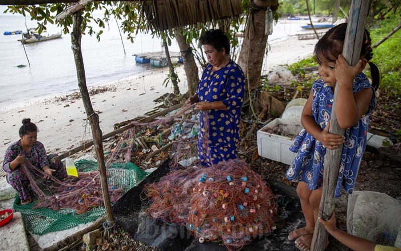 Dua warga memperbaiki jaring ikan di perkampungan nelayan Sembulang, Pulau Rempang, Batam, Kepulauan Riau, Minggu (17/9/2023). Sejak dua pekan terakhir nelayan di pulau tersebut tidak melaut dampak dari rencana relokasi warga untuk proyek strategis nasional (PSN) Rempang Eco-City Pulau Rempang. ANTARA FOTO/Teguh Prihatna