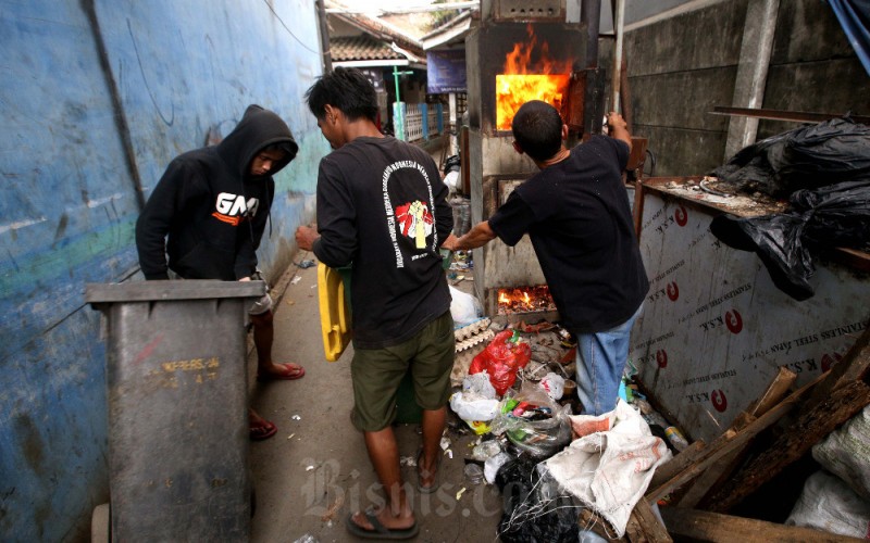 Yosef Barkah Ibrahim (kanan) membakar sampah menggunakan insinerator ciptaannya di Kampung Warung Nangka, Cibaduyut, Bandung, Jawa Barat, Senin (18/9/2023). Warga Bandung, Yosef, secara swadaya berhasil menciptakan alat pemusnah sampah tanpa listrik, tanpa bahan bakar minyak, bahkan diklaim tanpa asap dengan pembakaran sempurna. Alat pemusnah sampah atau insinerator kreasinya yang diberi nama Jozef-R-700 ini telah dimanfaatkan untuk mengatasi sampah rumah tangga lebih dari 400 kepala keluarga di wilayah tempat tinggalnya. Insinerator Jozef-R-700 diharapkan bisa menjadi solusi sampah yang menumpuk di wilayah Bandung Raya beberapa waktu lalu akibat penutupan TPA Sarimukti yang mengalami kebakaran. Bisnis/Rachmanrn