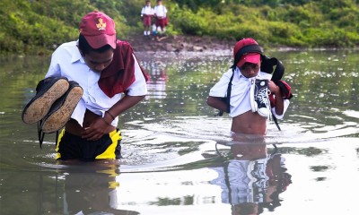 Siswa Menyeberangi Sungai Untuk Berangkat Sekolah
