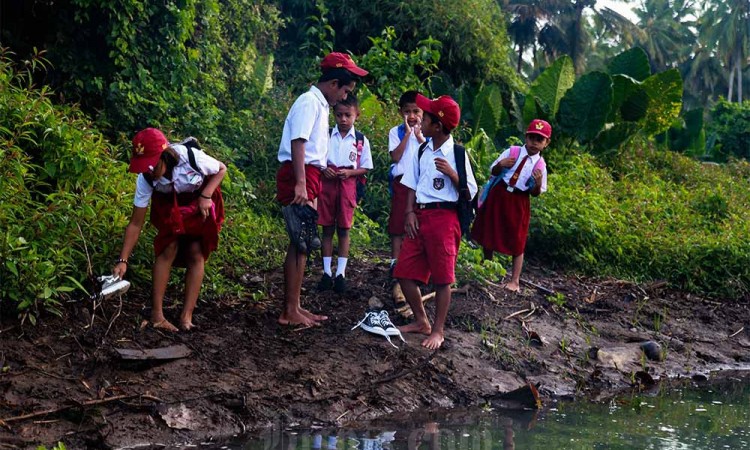 Siswa Menyeberangi Sungai Untuk Berangkat Sekolah