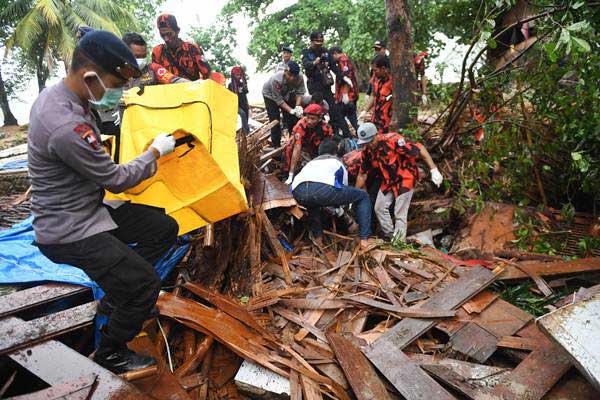 Polisi dan relawan mengevakuasi korban tewas akibat Tsunami yang tertimbun di bawah reruntuhan di kawasan Carita, Banten, Jawa Barat, Senin (24/12/2018). - ANTARA/Akbar Nugroho Gumay