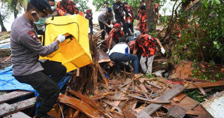 Polisi dan relawan mengevakuasi korban tewas akibat tsunami yang tertimbun di bawah reruntuhan di Carita, Banten, Senin (24/12/2018)./Antara-Akbar Nugroho Gumay