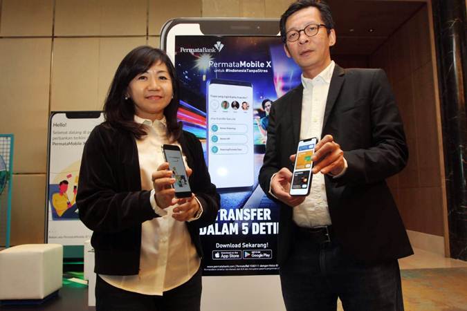 Direktur Retail Banking Permata Bank Djumariah Tenteram (kiri) bersama Direktur Teknologi & Operasi Abdy D. Salimin memperlihatkan aplikasi PermataMobile X menggunakan smartphone, di Jakarta, Jumat (25/1/2019). - Bisnis/Endang Muchtar