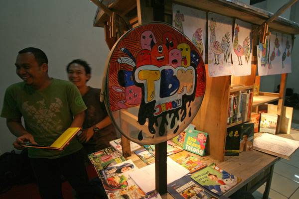 Warga membaca buku koleksi taman baca masyarakat Gelaran Jambu di Monumen Simpang Lima Gumul, Kediri, Jawa Timur, Jumat (24/3) malam./Antara