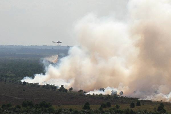 Helikopter BNPB jenis MI-8 melakukan pengeboman air di atas areal hutan dan lahan yang terbakar di Desa Medang Kampai, Dumai, Riau, Selasa (9/8)./Antara