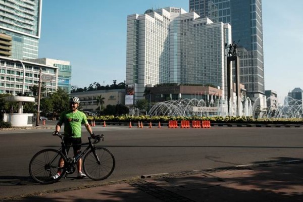 Warga memanfaatkan momen Ibu Kota sepi dengan berfoto dan berolahraga di sekitar Bundaran Hotel Indonesia, Jakarta, Rabu (5/6/2019)./Bisnis-Felix Jody Kinarwan