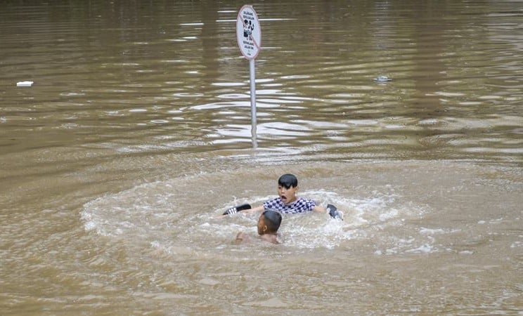 Sejumlah anak bermain saat banjir - ANTARA / Galih Pradipta