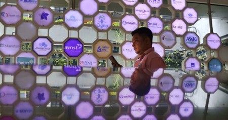 Karyawan berdiri di dekat logo perusahaan asuransi di kantor Asosiasi Asuransi Jiwa Indonesia (AAJI), di Jakarta, Selasa (15/1/2019)./Bisnis-Nurul Hidayat