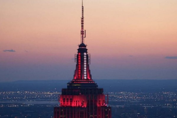 Empire State Building memancarkan warna merah dan putih.