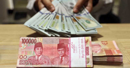 Karyawan menunjukan uang dolar Amerika Serikat (AS) di Jakarta, Senin (18/5/2020). Bisnis/Eusebio Chrysnamurti