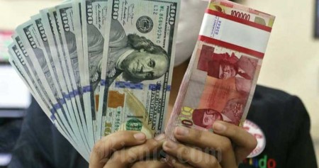 Karyawan menunjukan uang dolar Amerika Serikat (AS) dan Rupiah di salah satu gerai penukaran mata uang asing di Jakarta, Rabu (22/7/2020). Bisnis/Eusebio Chrysnamurti 