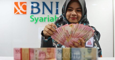 Karyawan menghitung uang rupiah di Kantor Bank BNI Syariah di Jakarta, Senin (24/2/2020)./Bisnis-Eusebio Chrysnamurti