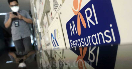 Karyawan beraktifitas di dekat deretan logo-logo perusahaan asuransi di Kantor Asosiasi Asuransi Umum Indonesia (AAUI) di Jakarta, Selasa (22/9/2020). Bisnis/Himawan L Nugraha