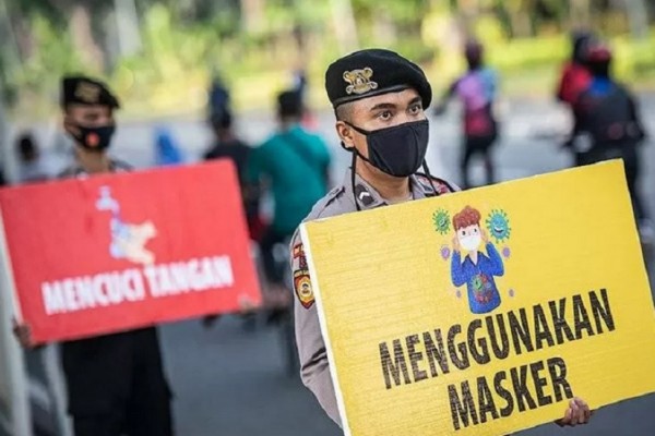 Personel gabungan TNI dan Polri membagikan masker saat kampanye Protokol Kesehatan Covid-19 di kawasan Pasar Tanah Abang, Jakarta, Minggu (31/1/2021)./Antara