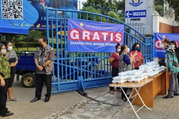 Jajaran pimpinan dan staf Universitas Kristen Indonesia menyediakan paket sarapan dan vitamin gratis untuk warga yang melintas depan kampus UKI, Jakarta, Kamis (18/3/2021). /ANTARA