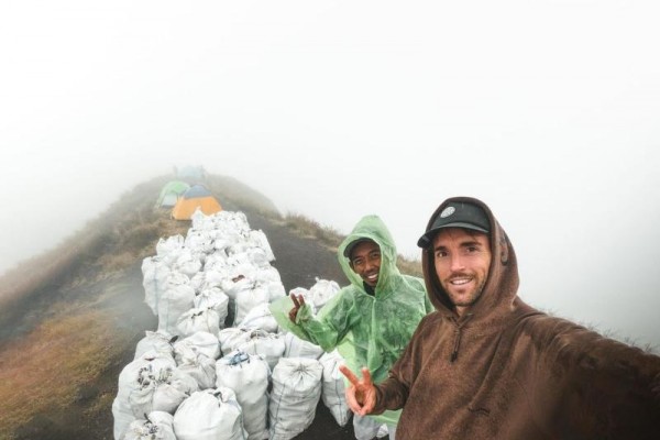 Benjamin Ortega sedang berfoto dengan salah satu tim ekspedisi, berlatar belakang sampah-sampah di dalam karung./Instagram @benjaminortega