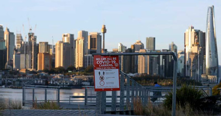 Papan pemberitahuan yang memperingatkan Kita semua bisa menjadi pembawa Covid-19 berada di tempat publik di Sydney, Australia, Selasa (27/7/2021). Setelah sebulan melakukan Lockdown, kasus harian Covid-19 di kota Sydney tidak menunjukkan tanda-tanda mereda. Bloomberg/Brendon Thorne