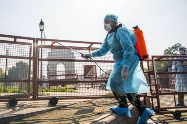 Petugas menyemprotkan disinfektan di dekat monumen India Gate di New Delhi, 22 Maret 2020./Prashanth Vishwanathan/Bloomberg