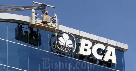 Pekerja membersihkan dinding kantor Bank Central Asia (BCA) di Makassar, Sulawesi Selatan, Selasa (16/6/2020). Bisnis/Paulus Tandi Bone