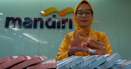 Karyawan menghitung uang pecahan Rp100.000 disalah satu kantor cabang milik PT Bank Mandiri (Persero) Tbk yang ada di Jakarta, Senin (7/10). Bisnis/Nurul Hidayat